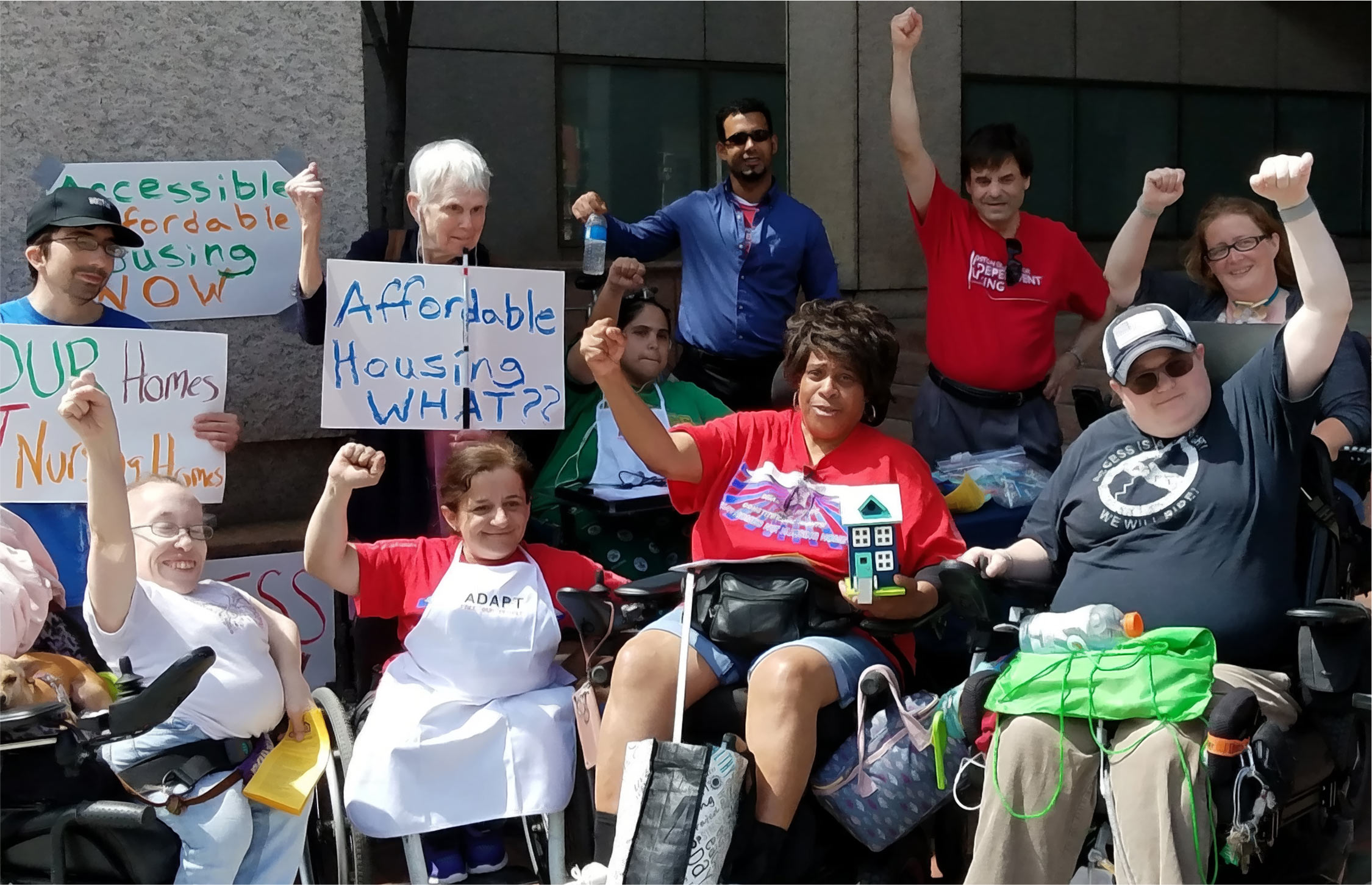Boston Center for Independent Living protest for affordable housing, diverse group of protestors holding their fists up